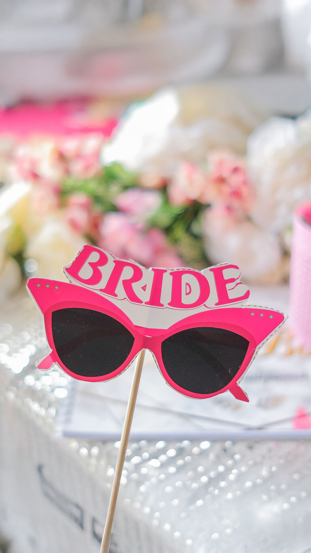 Stylish pink bridal goggles with 'Bride' written on them, adding a fun touch to wedding festivities.